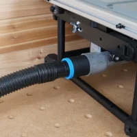 Black hose adapter with blue collar joining a 1-7/8 inch vacuum hose to a DeWalt table saw's rear dust port