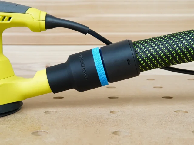 Black 36mm hose adapter with blue ring joining a braided extractor hose to a yellow Ryobi sander dust port