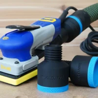 Two black ToolCurve 36mm hose adapters with blue ribbed collars beside a blue Ekasand sander and hose