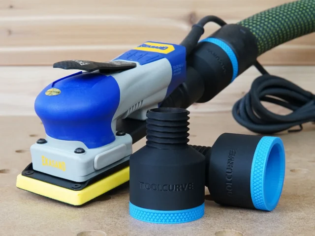 Two black ToolCurve 36mm hose adapters with blue ribbed collars beside a blue Ekasand sander and hose