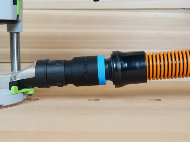 Black 1-1/4 inch hose adapter with blue band linking an orange hose to a 27mm Festool tool port