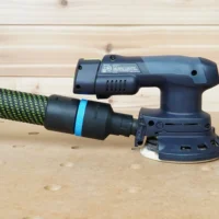 Black 36mm hose adapter with blue band linking a braided hose to the 27mm port on a Festool ETSC 125 sander