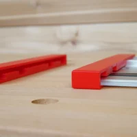 Red protective caps shown loose and installed on a Milwaukee aluminum guide rail