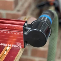 Black hose adapter mounted on red Woodpeckers DP-PRO 24 fence dust port with blue hose attached