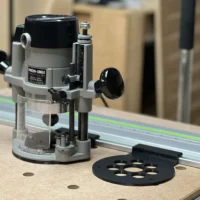 Porter Cable 690 router mounted on a Festool guide rail with a black ToolCurve adapter plate on the work surface