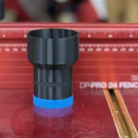 Black stepped ToolCurve hose adapter with blue base standing upright in front of a red Woodpeckers DP-PRO fence