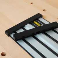 Black protective caps mounted on both ends of a Dewalt track saw rail, shown on a wooden workbench