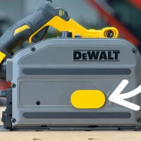 Yellow arbor dust cover snapped onto the side of a DeWalt track saw, marked by a white arrow