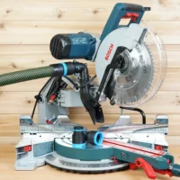 Black and blue 36mm hose adapter joining a green extractor hose to a Bosch 12-inch glide miter saw dust port, with a second adapter on the saw table