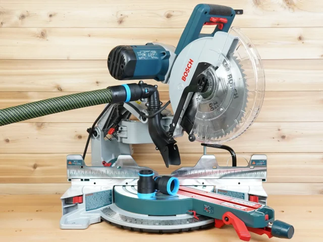 Black and blue 36mm hose adapter joining a green extractor hose to a Bosch 12-inch glide miter saw dust port, with a second adapter on the saw table