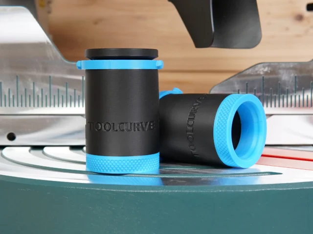 Two black hose adapters with blue grip bands, marked ToolCurve, shown standalone with measurement rulers in background