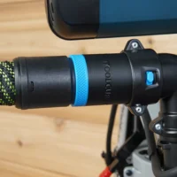 Black hose adapter with blue band attached to Bosch glide miter saw dust port, connected to green and black braided hose