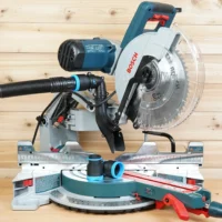 Black and blue 1-7/8 inch hose adapter linking a dust extractor hose to a Bosch 12-inch glide miter saw port, with a second adapter on the saw table