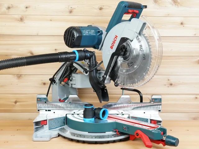 Black and blue 1-7/8 inch hose adapter linking a dust extractor hose to a Bosch 12-inch glide miter saw port, with a second adapter on the saw table