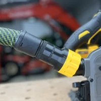 Black hose adapter with yellow collar attached to a DeWalt tool's quick-connect port, green hose fitted onto the adapter