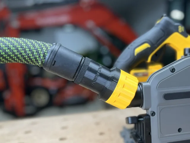 Black hose adapter with yellow collar attached to a DeWalt tool's quick-connect port, green hose fitted onto the adapter