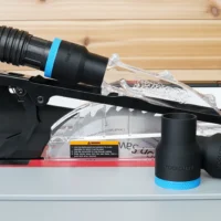 Black ToolCurve 1-7/8 inch hose adapter with blue ring joining a vacuum hose to a SawStop jobsite saw blade guard, plus two spare adapters
