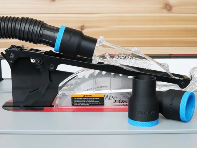 Black ToolCurve 1-7/8 inch hose adapter with blue ring joining a vacuum hose to a SawStop jobsite saw blade guard, plus two spare adapters