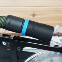 Black hose adapter with blue band installed on SawStop table saw blade guard, green and black braided hose attached
