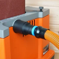 Black 1-1/4 inch hose adapter with blue collar joining an orange vacuum hose to a Ridgid edge sander dust port