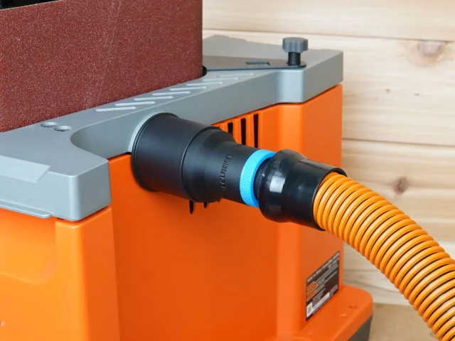 Black 1-1/4 inch hose adapter with blue collar joining an orange vacuum hose to a Ridgid edge sander dust port