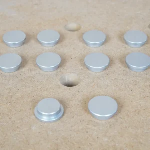 Ten 20mm aluminum bench dog hole button protectors with stepped underside, set on an MFT-style holed top