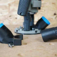 Black 1-7/8 inch hose adapter with blue rim and mounting screw beside a Bosch 1617 plunge router base