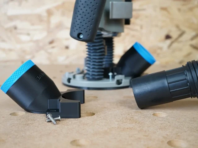 Black 1-7/8 inch hose adapter with blue rim and mounting screw beside a Bosch 1617 plunge router base