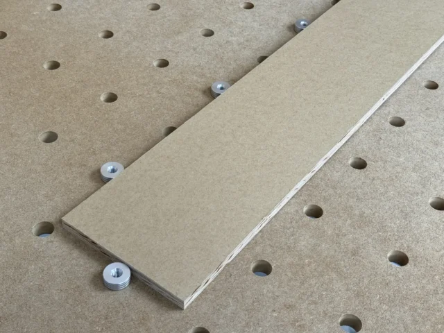 Four 20mm aluminum bench dogs with M8 threaded bases positioned on a pegboard workbench surface
