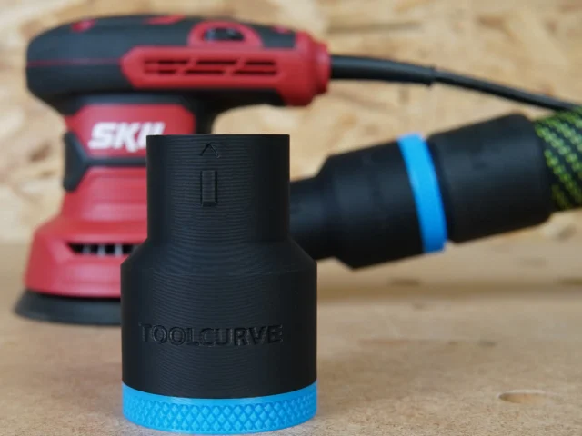 Black ToolCurve 36mm hose adapter with blue knurled collar standing in front of a red SKIL sander and hose
