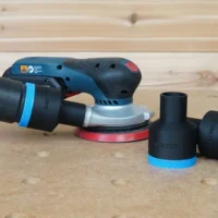 Black 36mm hose adapter with blue collar connecting a vacuum hose to a Bosch GEX sander, two spare adapters beside it
