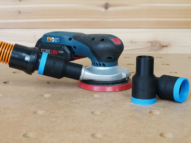 Black ToolCurve 1-1/4 inch hose adapter with blue ring installed on a Bosch GEX 18v sander, plus two spares