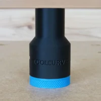 Black hose adapter with blue grip band and ToolCurve branding, shown at angle on wooden surface