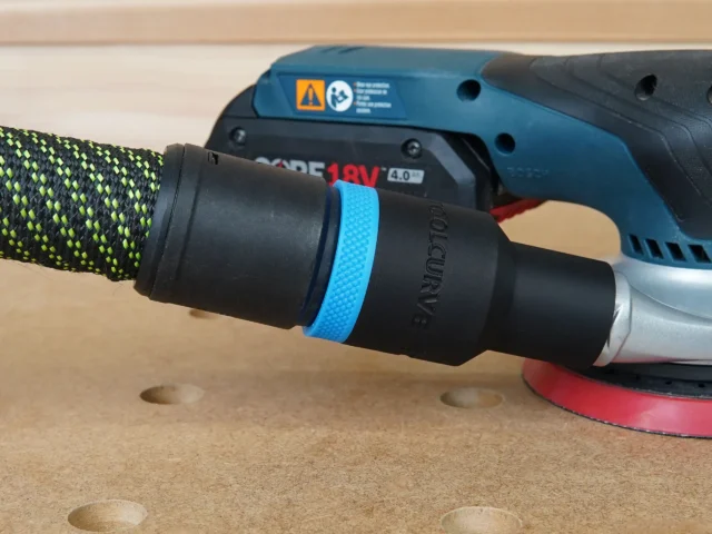 Black hose adapter with blue grip band attached to Bosch GEX 18v sander, connected to yellow and black dust hose