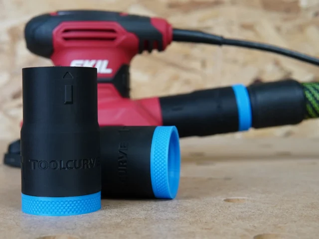 Black ToolCurve hose adapter with blue grip band, shown alone in foreground with SKIL sander in background