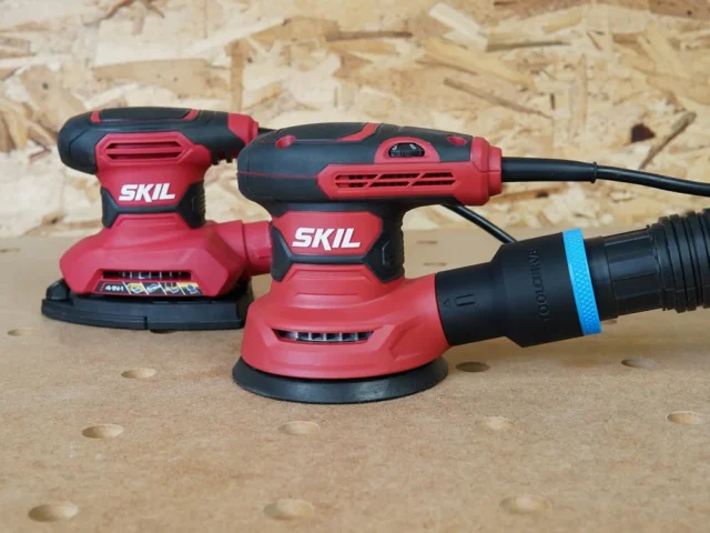 Black 1-7/8 inch ToolCurve hose adapter with blue band joining a vacuum hose to a SKIL orbital sander's rear port