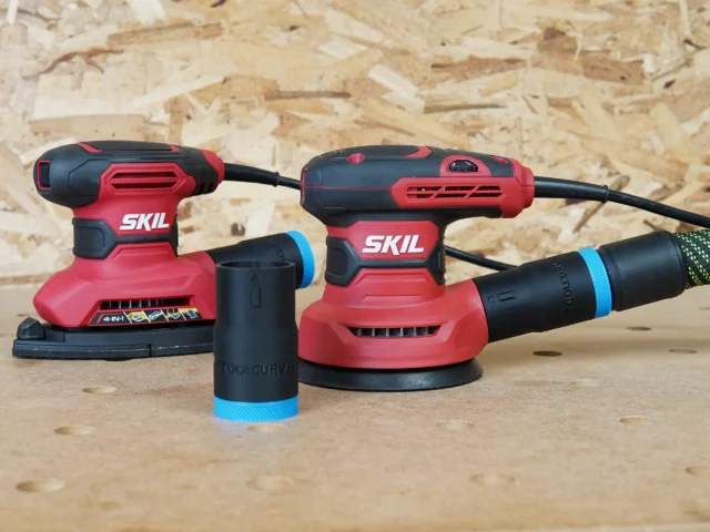 Black ToolCurve 27mm hose adapter with blue ring standing beside two SKIL sanders, one with hose attached