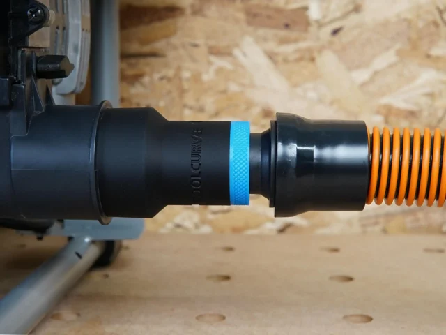 Black ToolCurve 1-1/4 inch hose adapter with blue band joining a SKIL table saw dust port to an orange hose