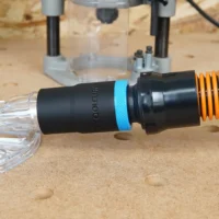 Black ToolCurve 1-1/4" hose adapter with blue ring joining an orange vac hose to a clear Oneida router hood