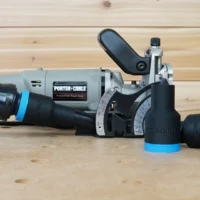 Black ToolCurve 1-1/4" hose adapter with blue collar fitted to a Porter Cable 557 plate joiner, two spare adapters beside it