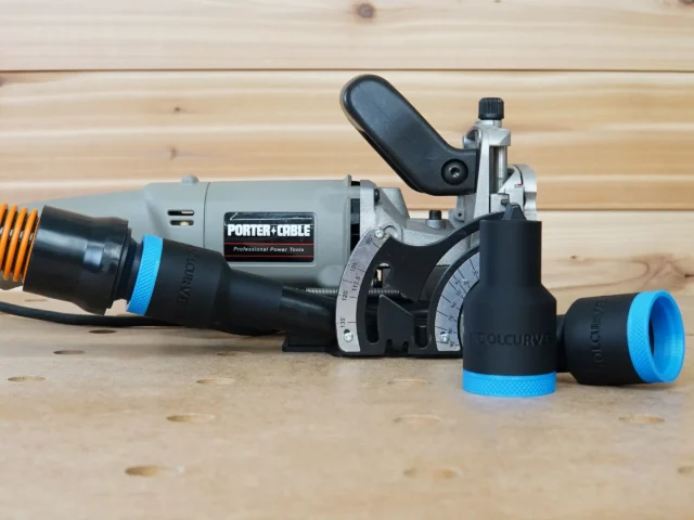 Black ToolCurve 1-1/4" hose adapter with blue collar fitted to a Porter Cable 557 plate joiner, two spare adapters beside it