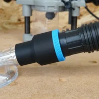 Black 1-7/8 inch hose adapter with blue grip ring joining a vacuum hose to a clear Oneida router hood port