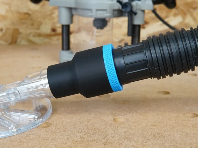 Black 1-7/8 inch hose adapter with blue grip ring joining a vacuum hose to a clear Oneida router hood port