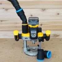 Black 1-7/8 inch hose adapter with blue cuff on a Dewalt cordless plunge router, second adapter on bench