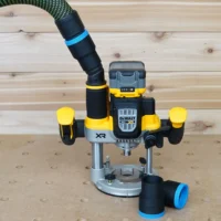 Black 36mm hose adapter with blue band resting beside a DeWalt 20V XR plunge router, hose connected above