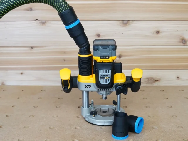 Black 36mm hose adapter with blue band resting beside a DeWalt 20V XR plunge router, hose connected above