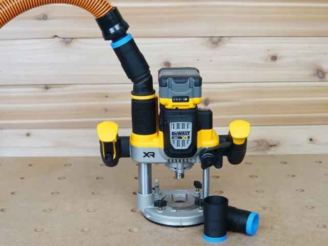 Black 1-1/4 inch hose adapter with blue band linking an orange vac hose to a DeWalt cordless plunge router, second adapter beside it