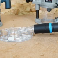 ToolCurve hose adapter with blue band attached to Oneida Universal Router Hood dust port on workbench