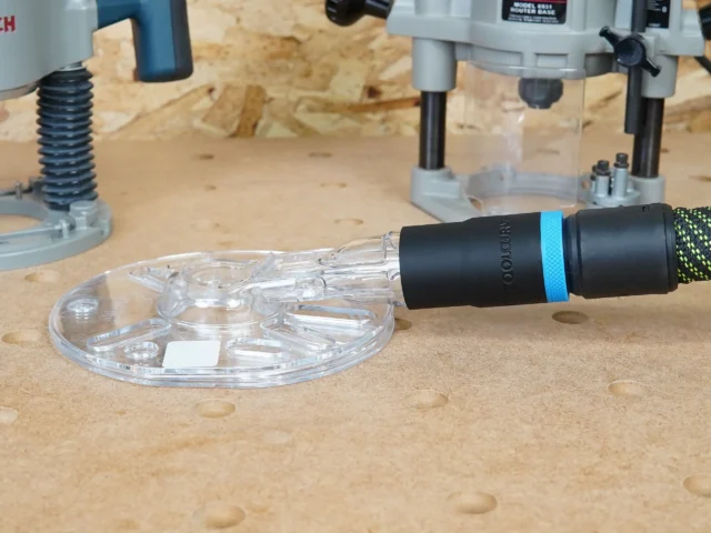 ToolCurve hose adapter with blue band attached to Oneida Universal Router Hood dust port on workbench