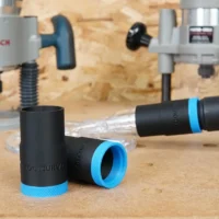 Black hose adapter with blue grip band for Oneida router hood, shown disconnected and connected to clear tubing on workbench
